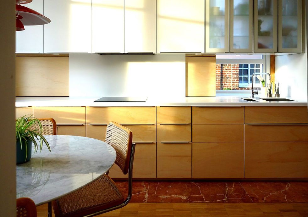 Cocina de diseño elegante con armarios de madera natural, encimeras de mármol claro y suelo de mármol granate con veteado.