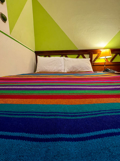multicolored bedspread in room at San Salvador hotel
