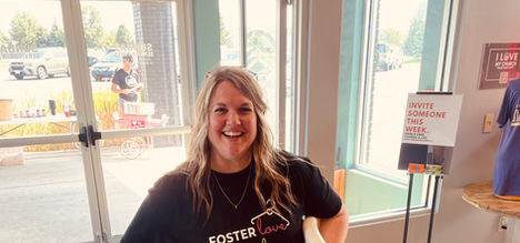 Woman smiling, holding chairs; Foster Forever Foster Youth