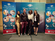 Grupo de cuatro personas posando con el logo de Disney Cruise Line