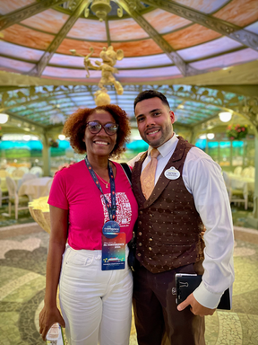 Dos personas posan juntas en una foto con decoración, Disney Cruises line.