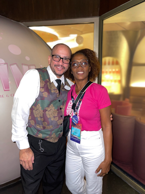 Dos personas posan juntas, sonriendo. Marco y una mujer en el Vip Caribbean Office.