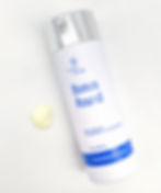 White bottle of Linder Health "Bonus Round" cream with silver cap on white surface. Cream dab nearby. Text includes "Formulating the Future."