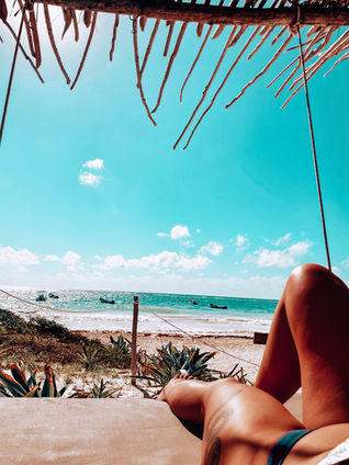 a person laying on a beach with boats in the distance