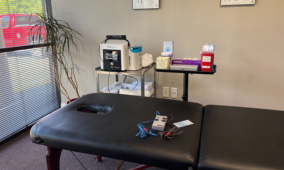 Chiropractic treatment room equipped with an electrical stimulation unit and supplies for dry needling therapy.