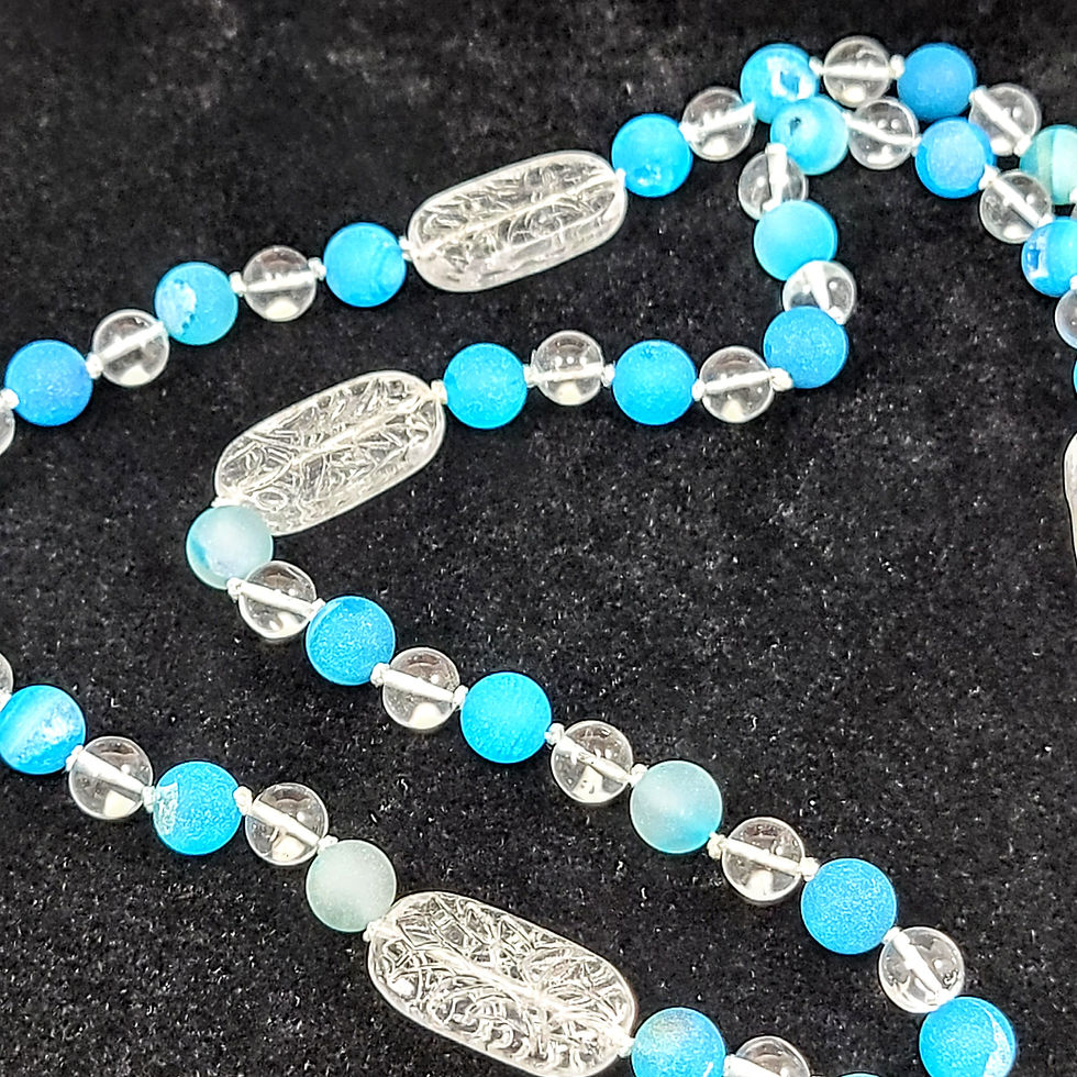 Thumbnail: knotted necklace of blue druzy agate, round clear quartz, pressed Czech glass ovals lying on dark background