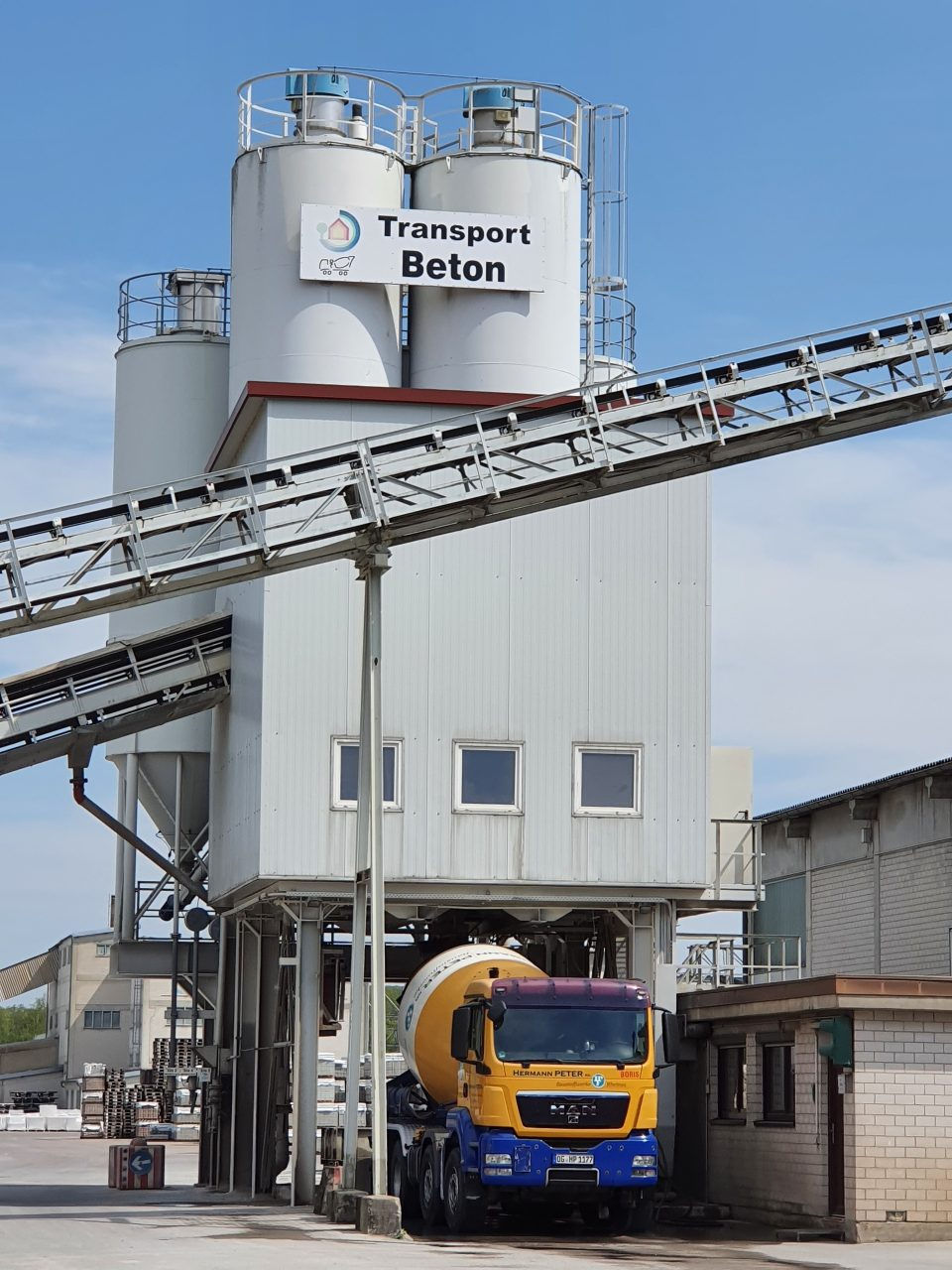 Betonmischer der im Transportbetonwerk geladen wird.jpg