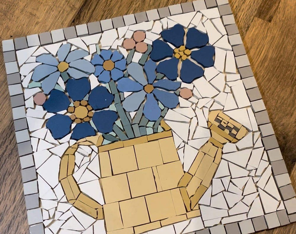 Blue flowers in a watering can mosaic