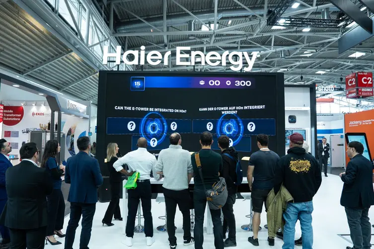 Grande schermo con domanda quiz in inglese e tedesco, pubblico coinvolto davanti allo stand Haier Energy all’Intersolar 2025.