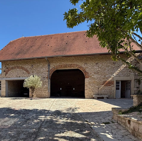 Depuis la cour, on découvre la grande grange en pierre qui abrite le garage du gîte.
Cet espace spacieux et sécurisé, avec sa porte motorisée, permet de garer facilement votre voiture, moto, quad ou vélo à l’abri.
La grange, au charme authentique, fait ainsi pleinement partie du confort proposé aux hôtes.