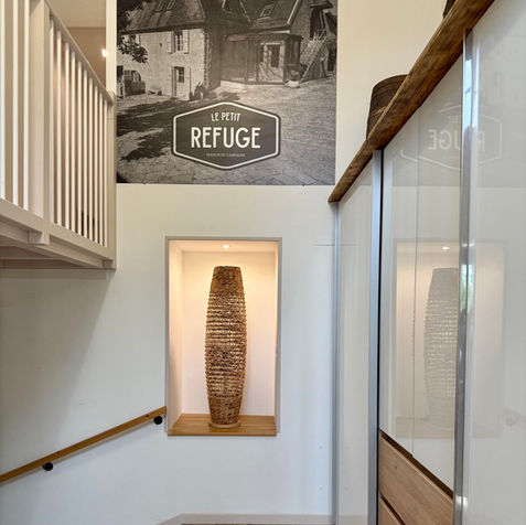 Pour parfaire l’ambiance cocooning de la belle entrée lumineuse du gîte, un lampadaire en osier tressé, diffusant une lumière douce et chaleureuse, crée un cocon lumineux qui invite à la détente dès les premiers pas franchis.