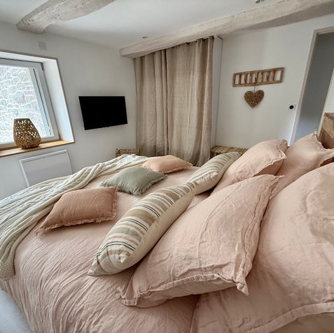 Plongez dans le confort de ce grand lit douillet, habillé de draps en lin aux teintes pastel et de coussins moelleux qui invitent à la détente. 

L’ambiance chaleureuse et naturelle, relevée par des touches de bois et de rotin, en fait une véritable chambre romantique au cœur du gîte Le Petit Refuge à Rahon 39120. 

Depuis la fenêtre, laissez-vous séduire par la vue apaisante sur le spa extérieur, promesse de moments de bien-être et de sérénité.