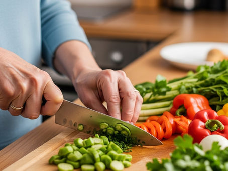 A warm kitchen counter with older adult hands chopping fresh vegetables, herbs