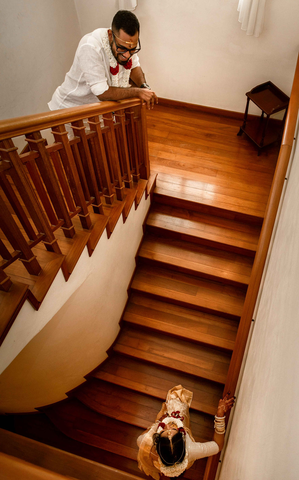 a man leans on the railing of a wooden staircase