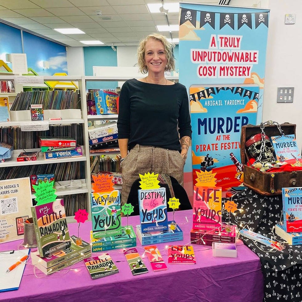 Abi, standing next to her author stall at the art event