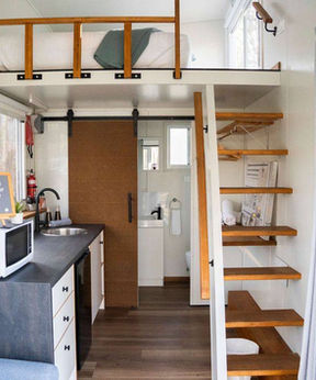 Inside a tiny house at Hidden Camp with kitchen and loft stairs