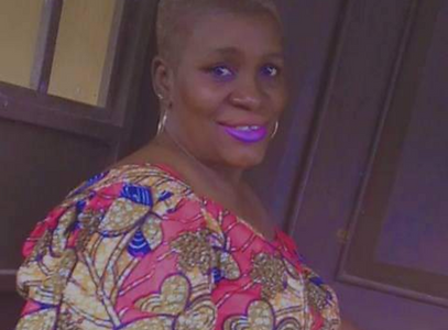 African woman smiling with short blonde hair and a colorful shirt