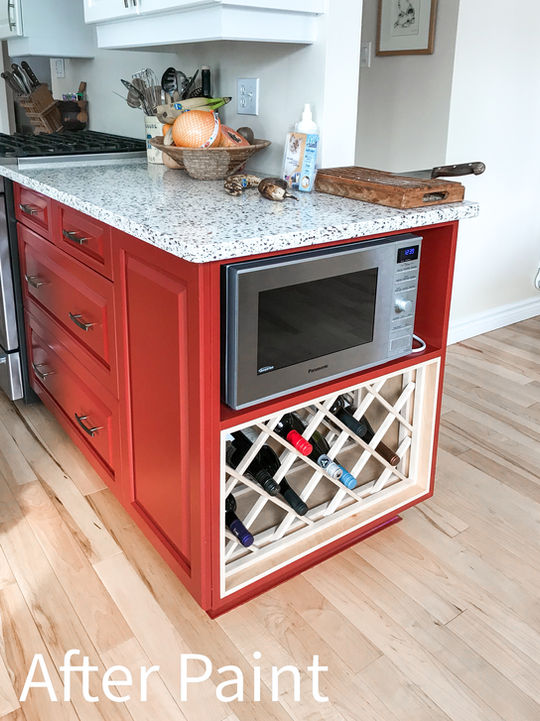 Red kitchen island with a microwave, wine rack, and text: After Paint
