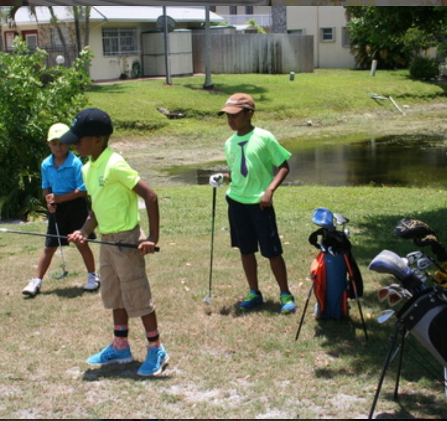 Three young golfers practicing at Klubs4Kids, a youth golf training program focused on skill development, sportsmanship, and mentorship in a community setting.