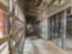 Framing lines a future hallway that'll divide two ground floor apartments from commercial spaces and their restrooms.