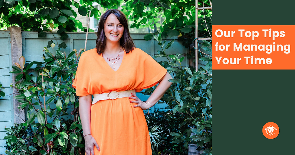 Hayley in an Orange dress with hand on hip.