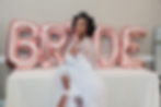 Bride posing in front of bride balloons in bridal robe