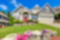 Grey house exterior with entrance porch and red door. Beautiful front yard landscape with