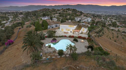 Twilight aerial view of a Norco ranch home with pool and surrounding acreage.