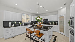 Bright modern kitchen with white cabinetry, center island, and natural light
