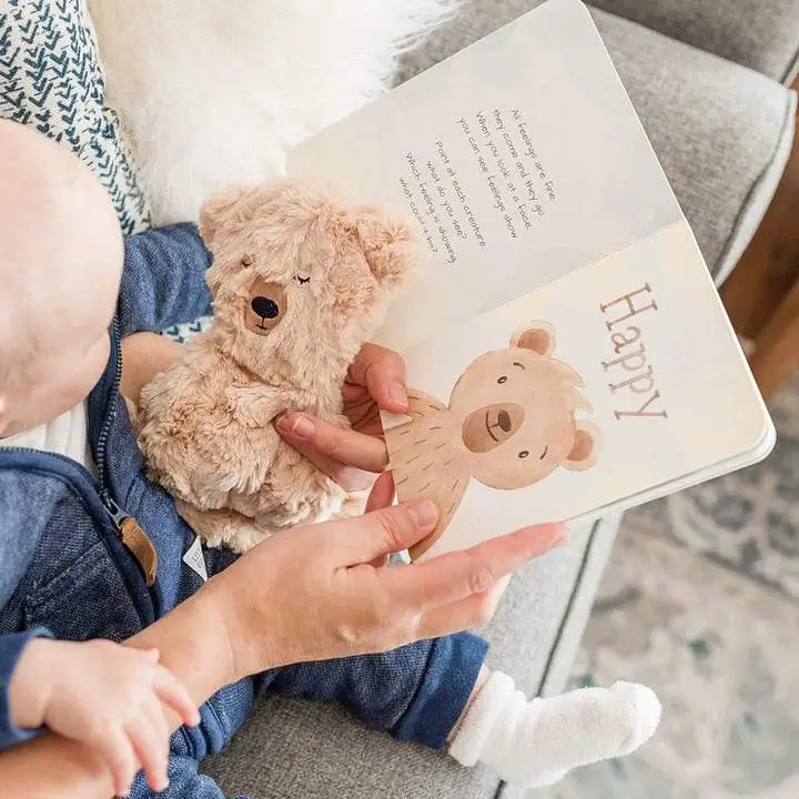 baby reading book with parent