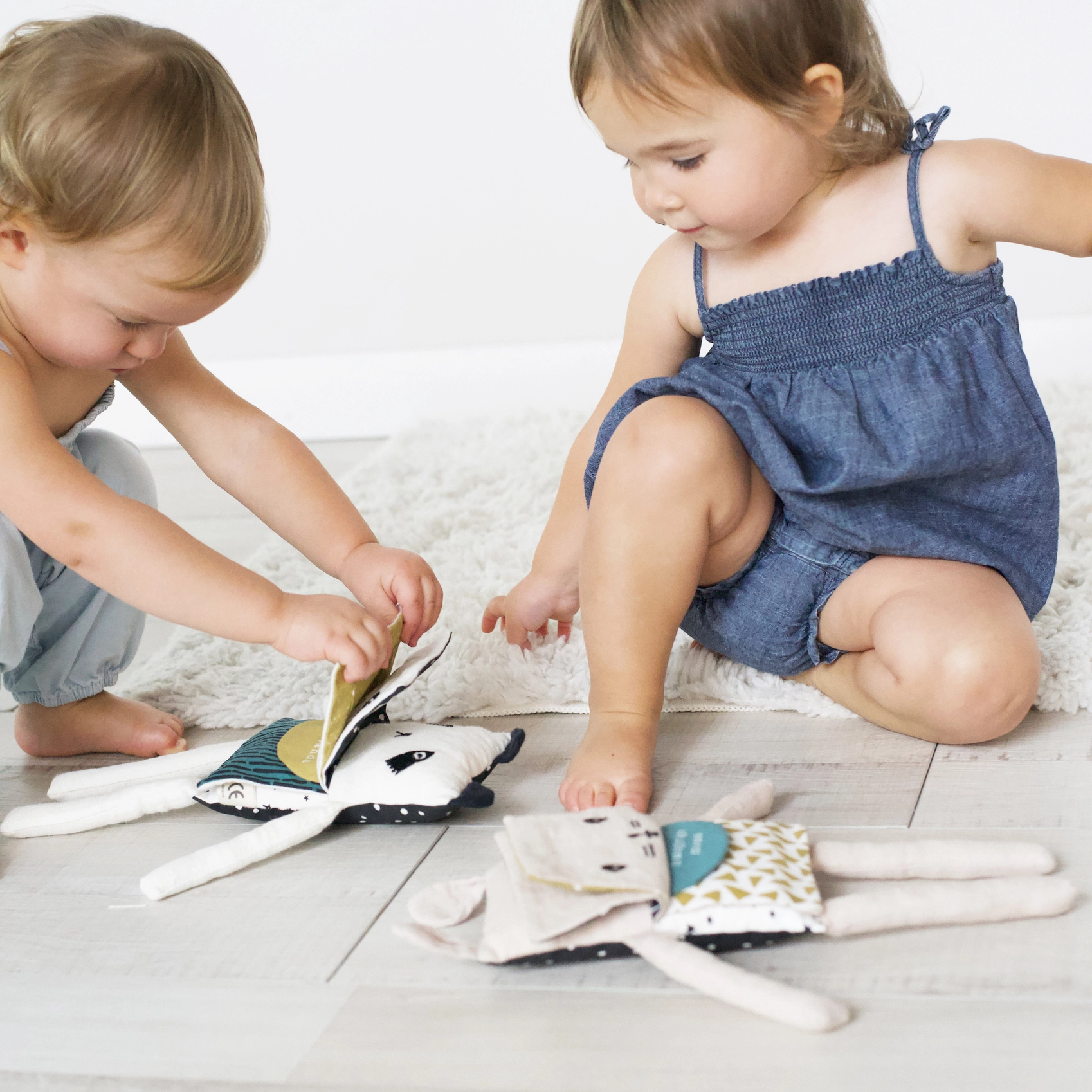 two toddlers playing with the social emotional bunny lovey 
