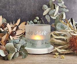 Glass tealight candle holder on faux marble tray with wording Be Brave in Silver wrapped around the cylinder and sandblasted clear daisy chain full wraparound cylinder.
