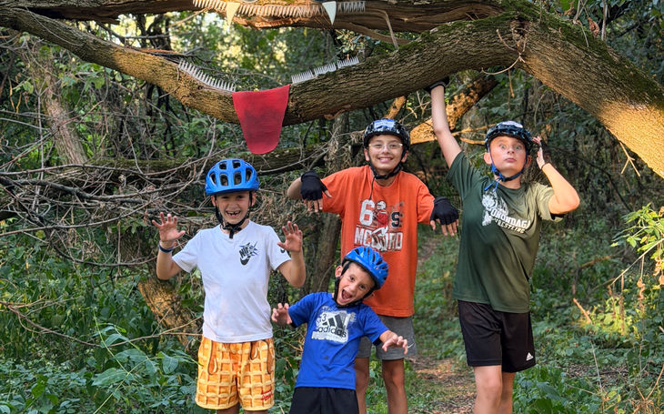 Riders standing together on a wooded trail during the fall program.