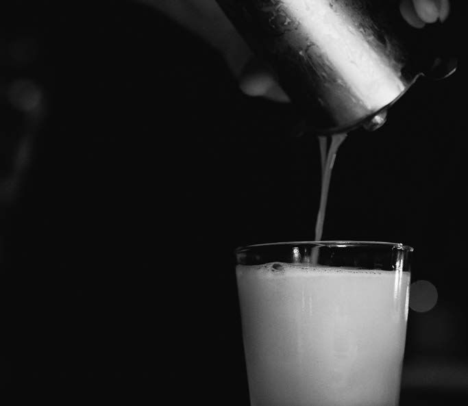 A cocktail is poured into a glass