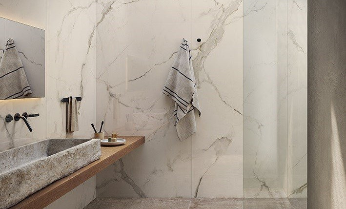 Calacatta light a large format porcelain slab wall application showing the flowing veins of this calacatta quartz in a bright and modern organic bathroom