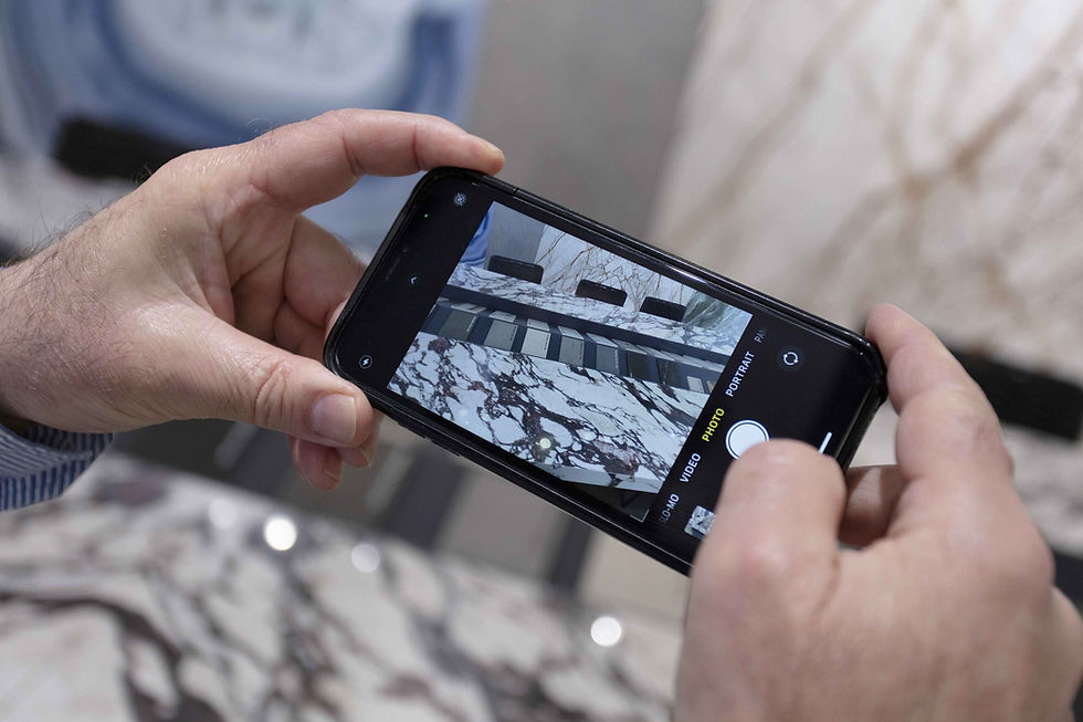 Person holding up an iPhone taking a picture of Verona porcelain countertops