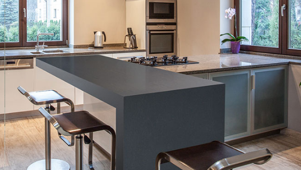 A modern kitchen with waterfall edge design featuring night life quartz