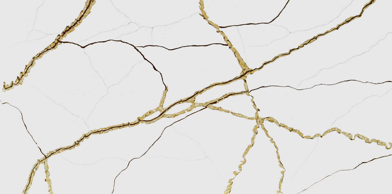 A white background stone that has gold veining that flows across the entire slab