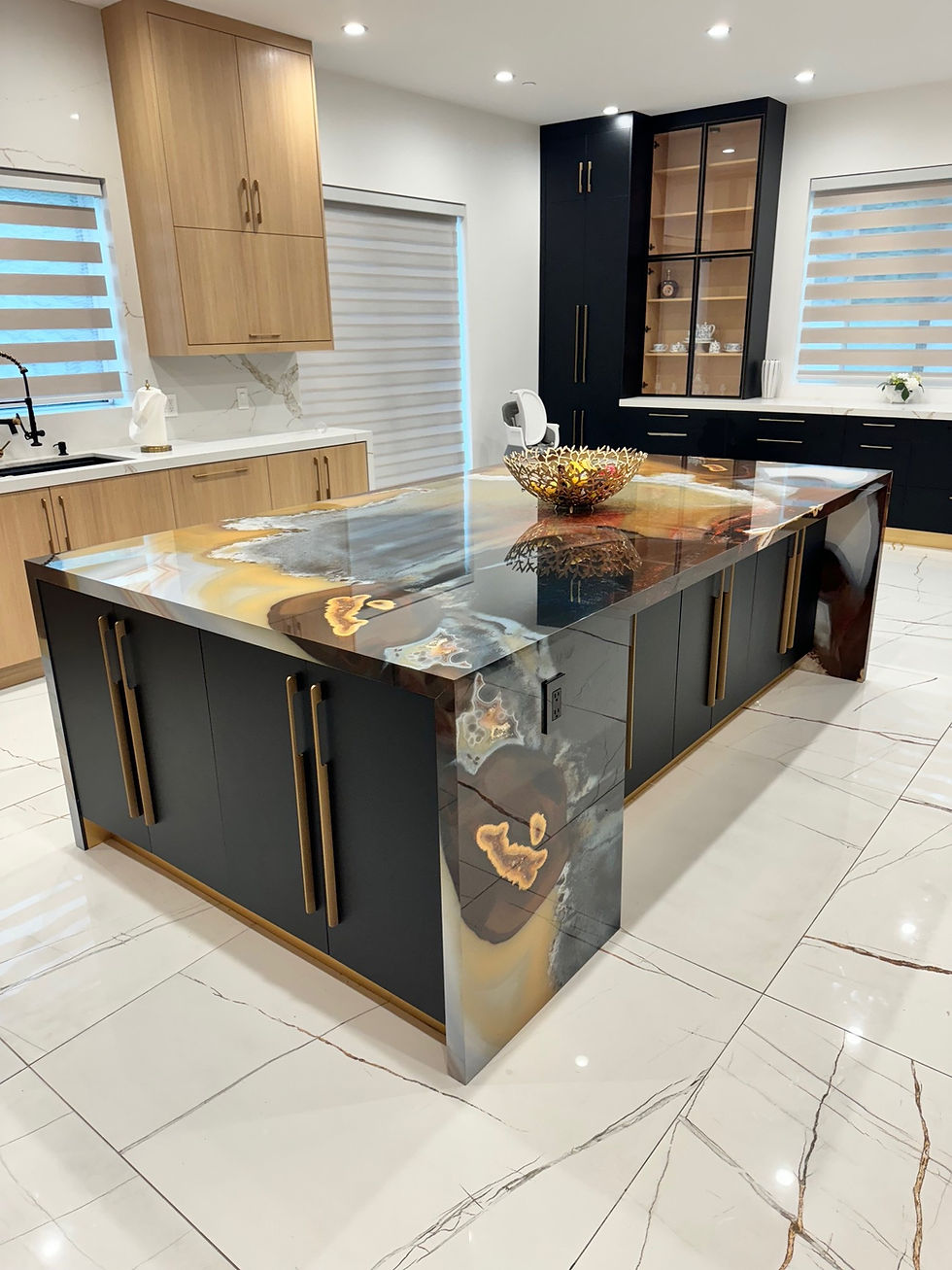 Modern white oak kitchen with marble look floors, and a stunning kitchen island made with Radiance porcelain