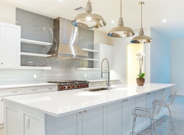 A white on white custom kitchen featuring sparkling white quartz countertops