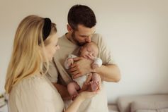 Eltern halten ihr Baby voller Liebe im Arm beim Homeshooting mit Sinja Walloschek von Seelengrafie.