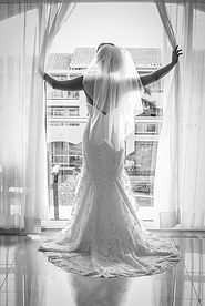 15 Black and white photo of bride in detailed lace dress and veil looking out window