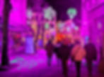 Promeneurs dans une rue illuminée de motifs fluorescents