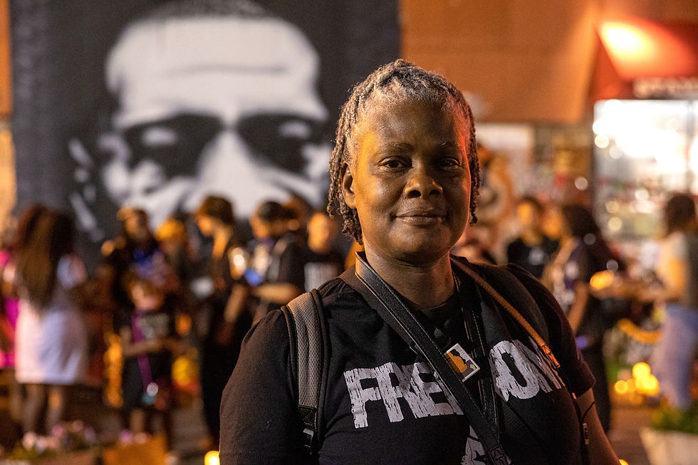 Shawn Batey picture in front of groups of people in front of large mural of George Floyd