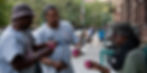 Three men at stoop in harlem, facing eachother holding coffee cups