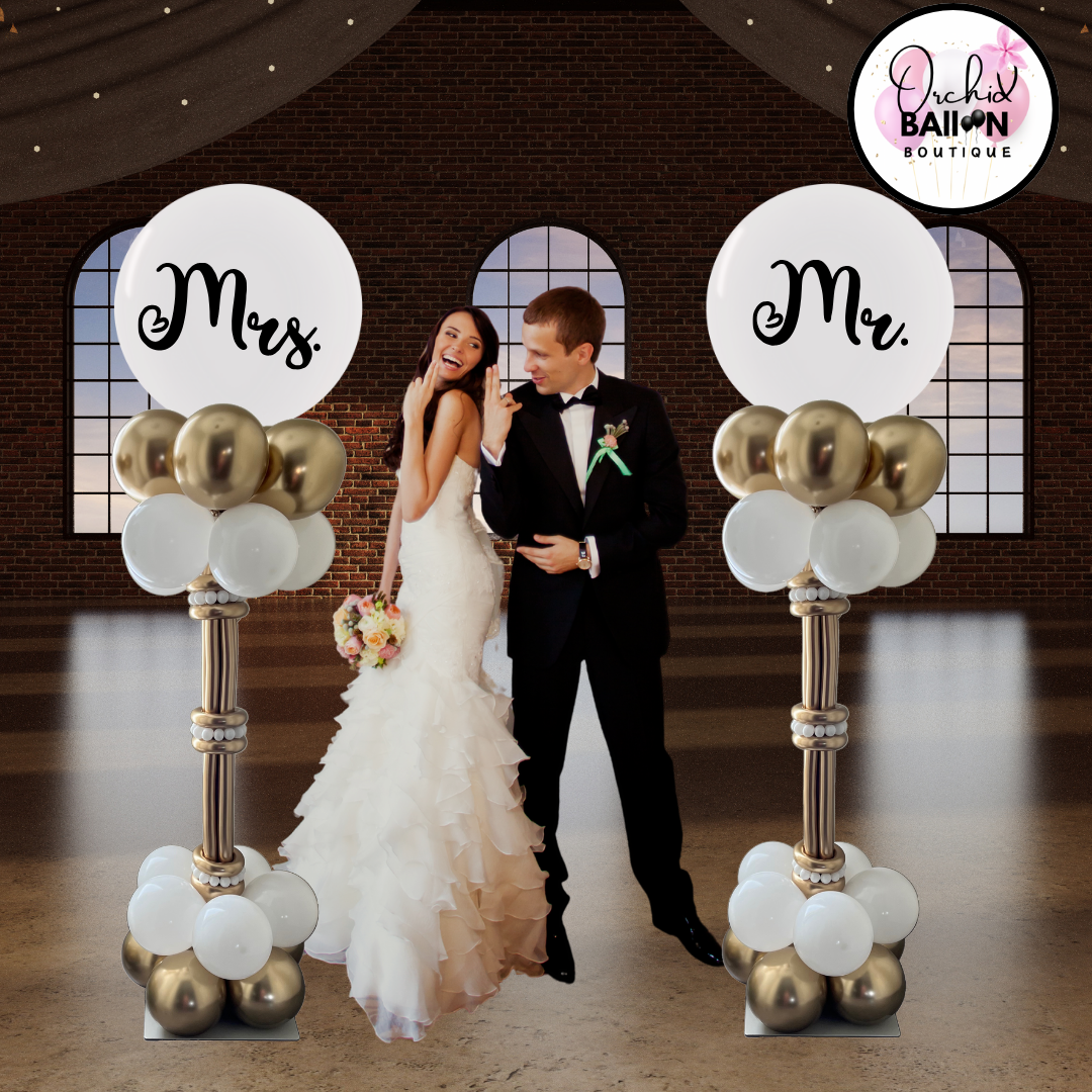 Elegant balloon columns with gold and white accents, topped with 'Mr & Mrs' balloons - perfect for wedding decor in Cochrane