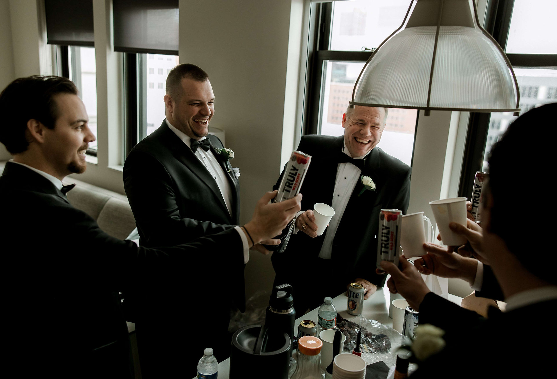 Groom and father toast in the hotel