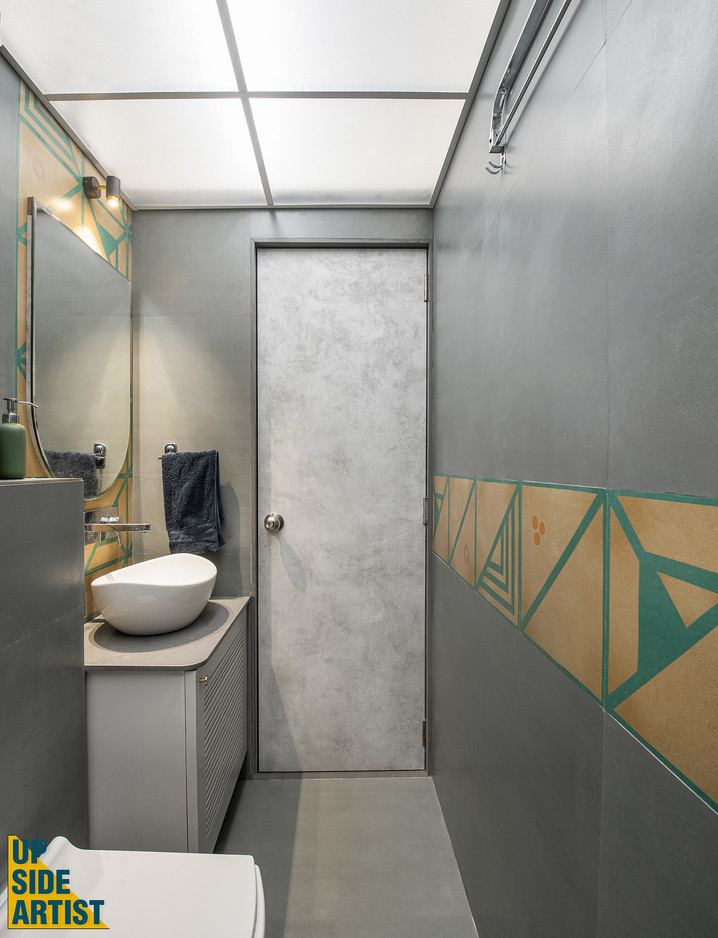 Contemporary powder room showcasing a white oval vessel sink on a grey floating cabinet, a backlit arch mirror, an abstract textured grey door, and a decorative geometric tile band along the wall.