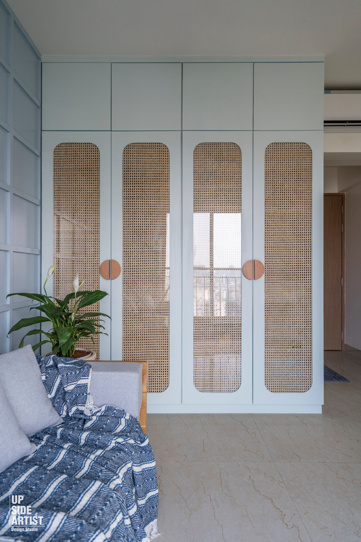 Contemporary light mint green wardrobe with floor-to-ceiling cabinetry, custom arched woven rattan panels, and circular wood handles.