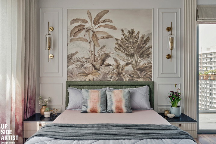Full front view of a master bed with a sage green velvet headboard, pink sheets, and coral-and-blue patterned pillows, flanked by twin white moulding panels with gold lights and a large jungle wallpaper centre piece.